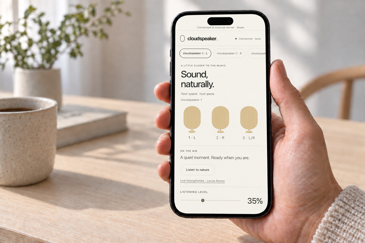 iPhone held in a hand, running the Cloudspeaker interface